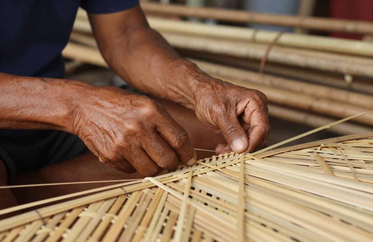 Close-up of Javanese artisan hands weaving rattan cane in traditional Indonesian pattern